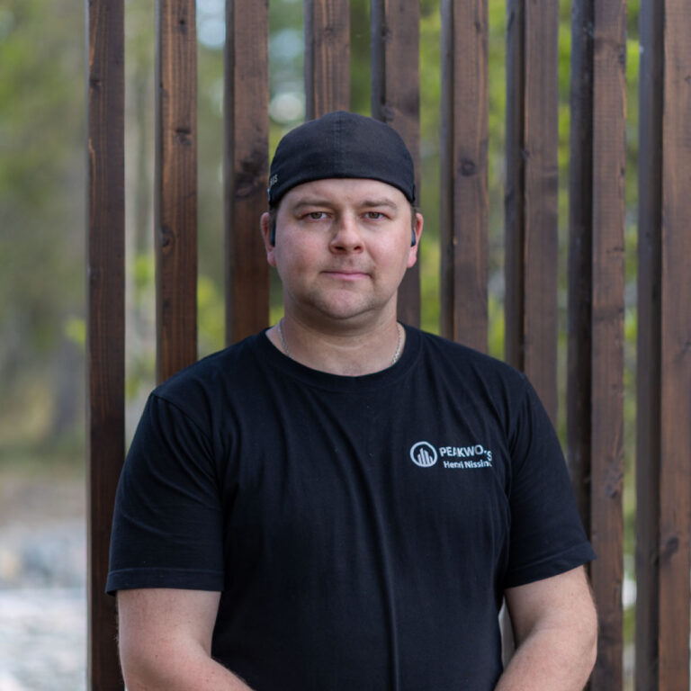 Man in a dark shirt, wood in the background.