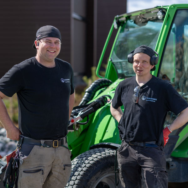 Two men in work clothes outdoors.